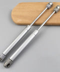 Ultra Sturdy Hydraulic Gas Spring Hinges For Cabinets And Lids With Soft Close Heavy Duty Kitchen Door Struts on wood background