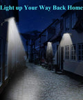 Street illuminated by wall-mounted lights at night, showcasing 3 Pack Dope 50W Blacklight Flood Lights 120V IP66 Waterproof UV LED For Indoor And Outdoor Use Landscape Decoration For Halloween Skeletons Ghosts Tombstones Body Paint Parties Wide Area Illumination For Large Spaces.