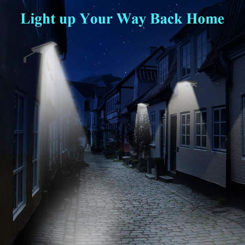Street illuminated by wall-mounted lights at night, showcasing 3 Pack Dope 50W Blacklight Flood Lights 120V IP66 Waterproof UV LED For Indoor And Outdoor Use Landscape Decoration For Halloween Skeletons Ghosts Tombstones Body Paint Parties Wide Area Illumination For Large Spaces.