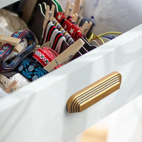 Installed Six Pack 5 Inch Antique Brass Cup Pulls With Distinctive Layered Ribbed Multi Sectioned Design on drawer