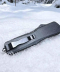 Folding Tactical Knife For Outdoor Adventures Multipurpose EDC Tool For Camping And Hiking Everyday Carry Black Finish Durable 80mm Blade 3mm Thick 18mm Wide High Quality Steel lying in snow