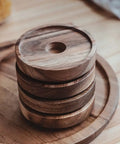 Top Shelf Airtight Glass Storage Jars With Smooth Acacia Wood Lids Keeps Your Daily Drip Locked Up Tight For Coffee Beans Tea And Dry Goods In This Bpa Free Four Pack Kitchen Essential with stacked wooden lids on a table.