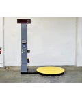 Heavy Duty Industrial Pre Stretch Wrapping Machine With Built In Scale And Thermal Label Printer No Sweat Operation Killer Five Thousand Pound Capacity Straight Shooter Wrap System, featuring a yellow turntable and digital display.