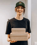 Woman in black shirt wearing Women's Lightweight Summer Trucker Cap Army Green Dope Everyday Wear Cotton Baseball Hat with boxes