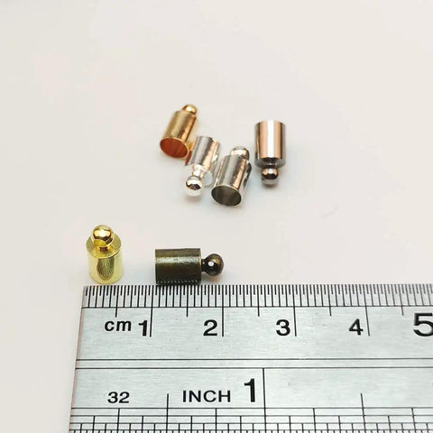 Dope Brass Cord End Caps Glue In 5x9mm set with ruler for scale, 6 colors: silver, gold, rose gold, nickel, gun black, bronze.