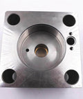 Waterjet intensifier end bell assembly (right), metal block with central bore and four mounting holes