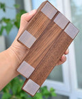 Hand holding Walnut Wood Door Stopper Wedge with PU Finish, showcasing bottom grip pads, Nordic style, for home and office use