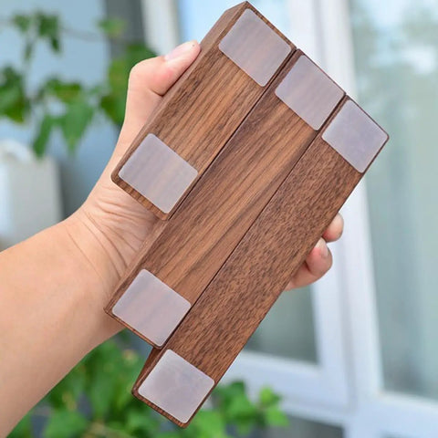 Hand holding Walnut Wood Door Stopper Wedge with PU Finish, showcasing bottom grip pads, Nordic style, for home and office use