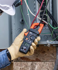 Electrician using Digital Clamp Meter With True RMS And LoZ Auto Ranging For AC And DC Voltage And Current Continuity Frequency Capacitance NCVT Temperature Diode Test 1000V Rating Built In Flashlight Rugged Pro Grade Tool on electrical panel