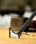 Close-up of a Rolling Head Pry Bar 12 Inch Heavy Duty Carbon Steel Leverage Tool for auto repair lifting a nail on wood surface.
