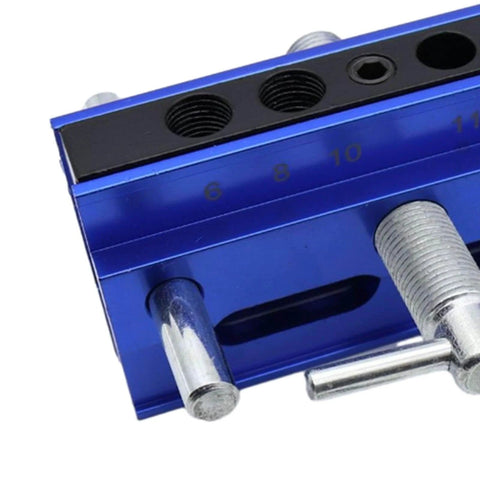 Close-up of adjustable doweling jig kit with six guide bushings showing measurement scale for woodworking.