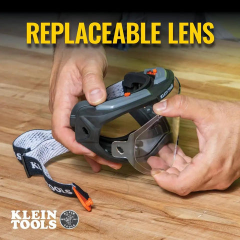 Hands holding clear lens safety goggles with anti fog scratch resistant eye protection PPE UV shield and adjustable vents