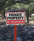 No Trespassing Private Property Sign 14x10 Inch Aluminum Weatherproof Outdoor Yard Fence Durable UV Printed Two Pack For Home And Biz Use Deter Intruders With High Visibility Red And Black in forest setting