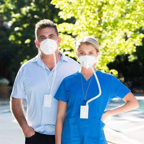 Two people wearing Air Pro Mask With HEPA Filter Rechargeable Reusable Respirator Powered Ventilation in outdoor setting