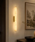 JCQASRT 19.69 in Modern Wall Sconce, 3-Color Changing LED Wall Light Fixture, illuminated brass and resin wall lamp in cozy interior.