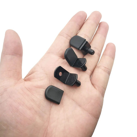 Hella Sturdy Cabinet Shelf Pins And Bracket Pegs With Rubber Sleeves For Adjustable Shelving Upgrades in hand, showcasing four black peg pieces.