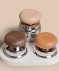 Professional Game Changer Espresso Coffee Tamper And Grounds Spinner Set featuring three wood handle tampers on a white base.