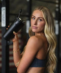 Woman holding Vacuum Insulated Protein Shaker Bottle Built For Totally Dead Silent Mixing And Sweat Proof Shell Locks Your Preworkout Ice Cold Through Savage Gym Sessions And Long Haul Drives In Matte Black.