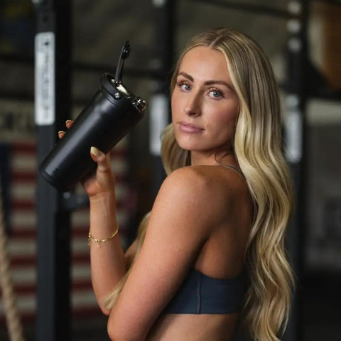 Woman holding Vacuum Insulated Protein Shaker Bottle Built For Totally Dead Silent Mixing And Sweat Proof Shell Locks Your Preworkout Ice Cold Through Savage Gym Sessions And Long Haul Drives In Matte Black.