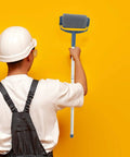 Person holding Extendable Paint Roller Kit With Long Handle Extension Pole For Hassle Free Wall And Ceiling Coverage against yellow wall.