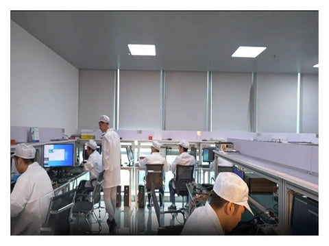 Technicians working in a modern electronics lab environment with computers and equipment