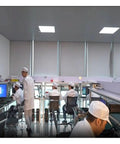 Technicians in a laboratory setting working at computer stations and assembling electronic components.