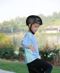 Child wearing Lightweight Multi Sport Helmet With Hard Abs Shell And Shock Absorbing Foam in outdoor setting.