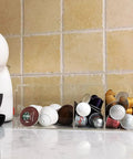 Clear Acrylic 4 Compartment Coffee Capsule Holder With Lid K Cup Organizer For Pods on kitchen counter with capsules sorted.