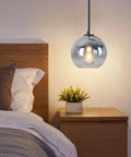 Modern Black Glass Globe Pendant Light Set, Silver Gradient Sphere Ceiling Fixture above nightstand, lit ambiance