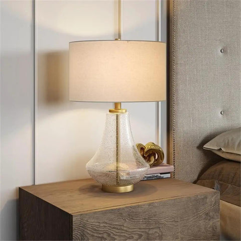 23 Inch Tall Table Lamp With Seeded Glass Shade Polished Nickel Finish And Flax Linen Fabric A Stylish Nightstand Or Side Table Light That Delivers Cozy Glow And Modern Vibe on wooden table beside bed