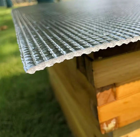 Close-up of Five Pack Thickened Aluminum Reflective Insulation Film For Beehives Waterproof Moisture Proof Sunshade on wooden hive
