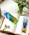 Camping Theme DIY Cross Stitch Bookmark Kit For Beginners, 6 Pack With Mountain View Motifs, on open book and flowers