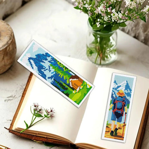 Camping Theme DIY Cross Stitch Bookmark Kit For Beginners, 6 Pack With Mountain View Motifs, on open book and flowers