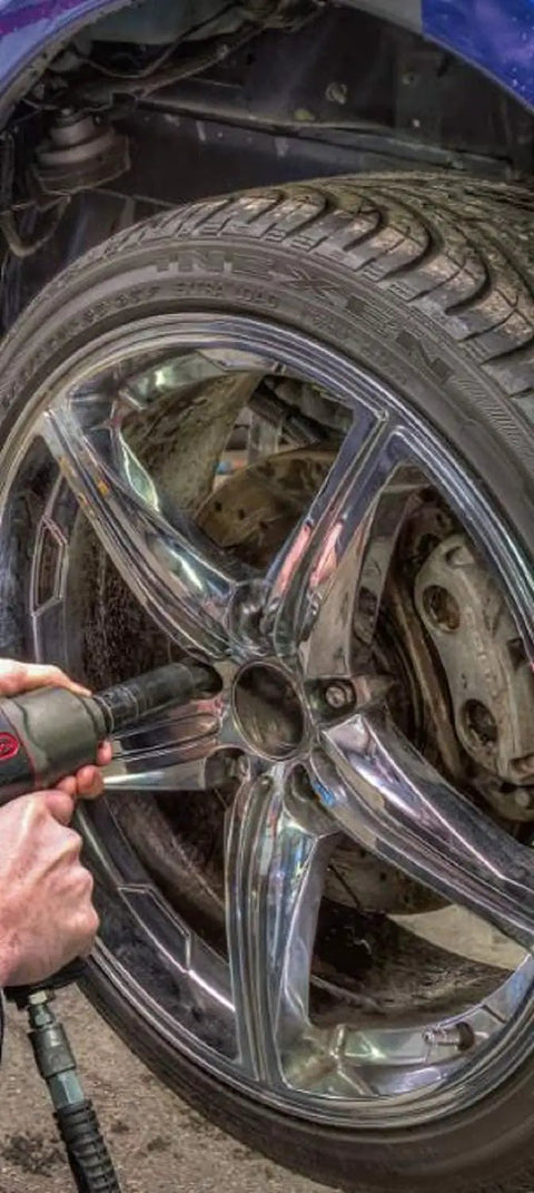 Mechanic using Deep Half Inch Drive Impact Socket Set 6 Point SAE 19 Piece Off Corner Loading Design on car wheel