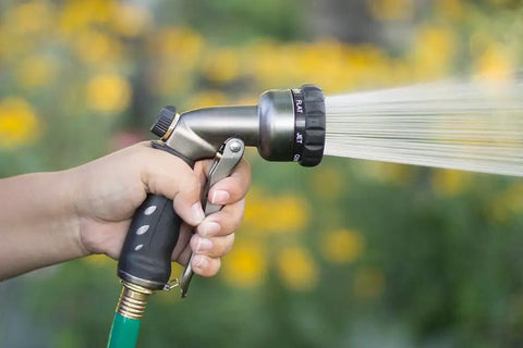 Hand using Seven Spray Patterns Garden Hose Nozzle With Easy Turn Dial And Flow Control For Precise Watering Of Lawns Pots And Garden Beds