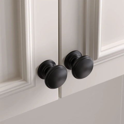 Bulk 25 Pack Black Cabinet Knobs Round Drawer Pulls Zinc Alloy Hardware on white cabinet doors showing sleek modern look.