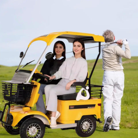 Kickin Up Dust 4 Wheel Electric Golf Cart Sweet Comfort Mobility Scooter for Mature Riders with two women sitting in bright yellow cart.
