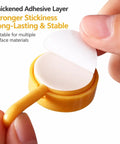 Sixteen Pack Dead Easy Colorful Adhesive Wall Hooks Self Stick Strong Tape No Drill Renter Friendly Low Key Decorative Style quick mount adhesive layer being peeled off.
