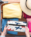 Person packing an Adorable Airplane Travel Makeup Bag For Women And Men in a suitcase, showcasing airplane design.