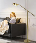 Metal Floor Lamp With Adjustable Swing Arm Reading Light, 9W Brass Task Lamp in living room next to black sofa