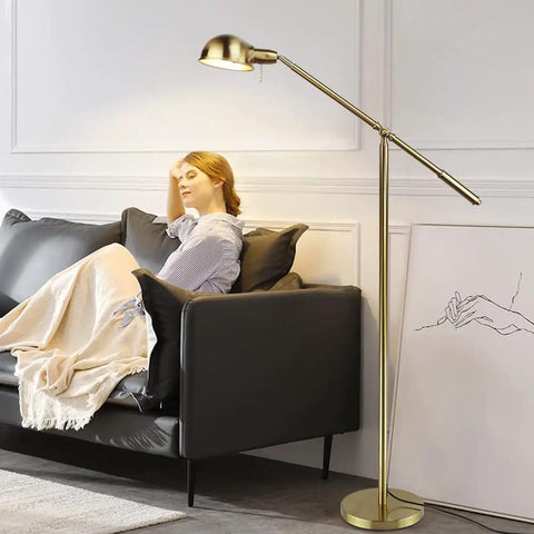 Metal Floor Lamp With Adjustable Swing Arm Reading Light, 9W Brass Task Lamp in living room next to black sofa