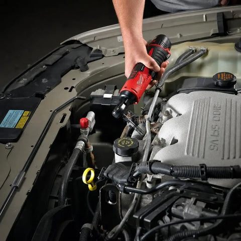 User operating Heavy Duty M12 Three Eighth Drive Cordless Ratchet Battery Operated Power Tool under vehicle hood.