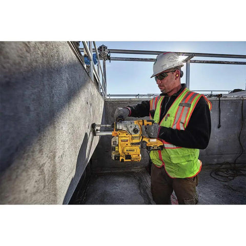 Worker using Onboard Dust Extractor for 1-1/8-Inch SDS Plus Rotary Hammers With Clear Dust Box and Replaceable Nozzle for drilling