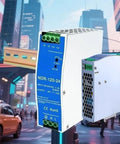 Rock Solid 24 Volt Dc Din Rail Power Supply 120 Watt Beefy Ac Dc Switching Module mounted on a cabinet in city background.