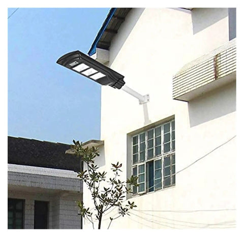 Badass Heavy Duty 350W Solar Floodlight With Photocensor And Motion Sensor Waterproof IP67 Outdoor Yard Security Lighting mounted on a wall.