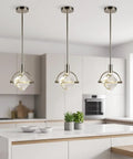 Lamparko Small Pendant Light Fixture with Crystal Cube, Brushed Nickel hanging above a modern kitchen island with plants.