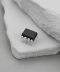 Close-up of a 10Pcs ICL7660 ICL7660S ICL7660SCPAZ CMOS Voltage Converter IC PDIP8 on a textured stone surface.