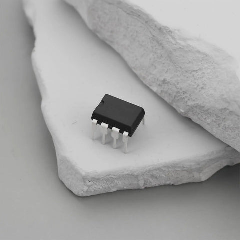 Close-up of a 10Pcs ICL7660 ICL7660S ICL7660SCPAZ CMOS Voltage Converter IC PDIP8 on a textured stone surface.