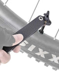 Hand using Power Lever X 5-In-1 Master Link Pliers And Tire Levers With Chain Hook Presta Core Tool on bike tire.