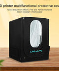 Upgraded 3D Printer Enclosure With LED Lighting And Temperature Control For Ender 3 V2 Ender 3 Pro Ender 5 And CR10S PRO V2 Insulated Fire Retardant Cover, showing black protective cover with clear viewing window on wooden table.